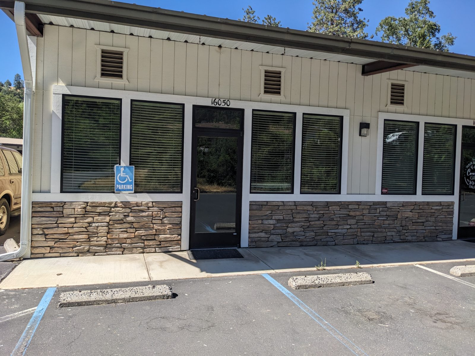 Storefront entrance at 16050 Via Este Road, with stone veneer and large display windows